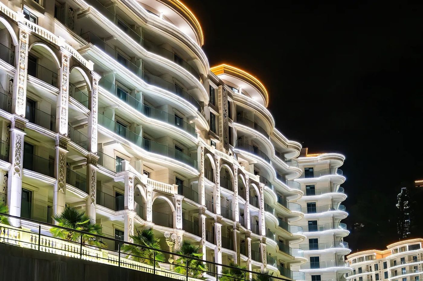 Корпуса Hotels & Resort ночью: подсветка балконов и арок на изогнутых фасадах