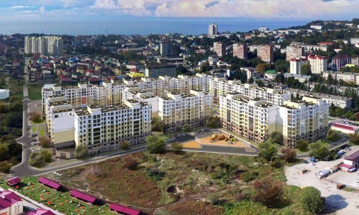 Визуализация: квартал десятиэтажных домов сверху среди частных домов посёлка, вдали многоэтажки и море